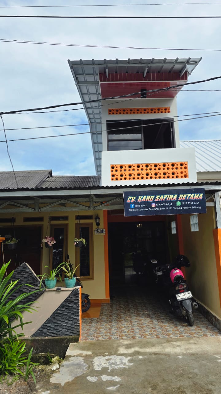 Modern office building with blue glass facade and hexagonal white decorative patterns on the lower floors, set under a bright blue sky with soft white clouds